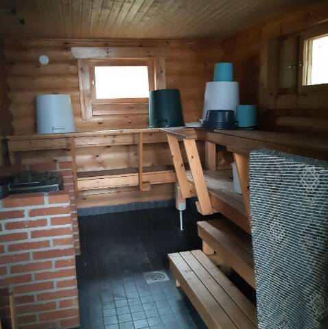 Kesijärven leirikeskuksen rantasauna sisältä, kuvassa kiuas ja lauteet.
