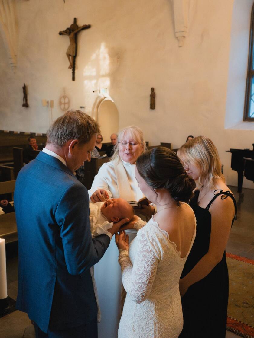 Kastetilaisuus jossa vanhemmat, kummit ja pappi.